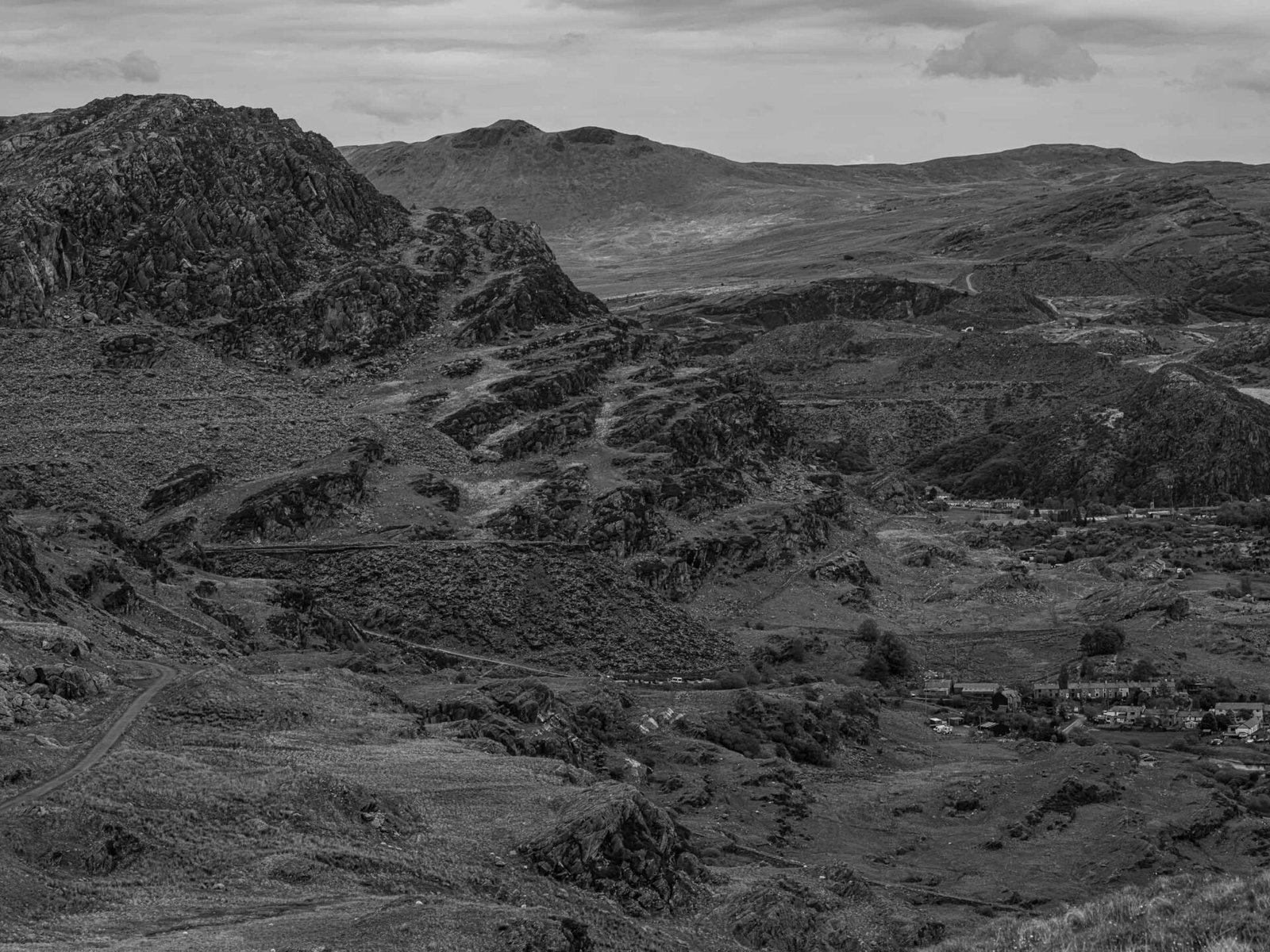 A wide view over the old Cwmorthin quarry workings, with the village of Tanygrisiau visible in the valley below.